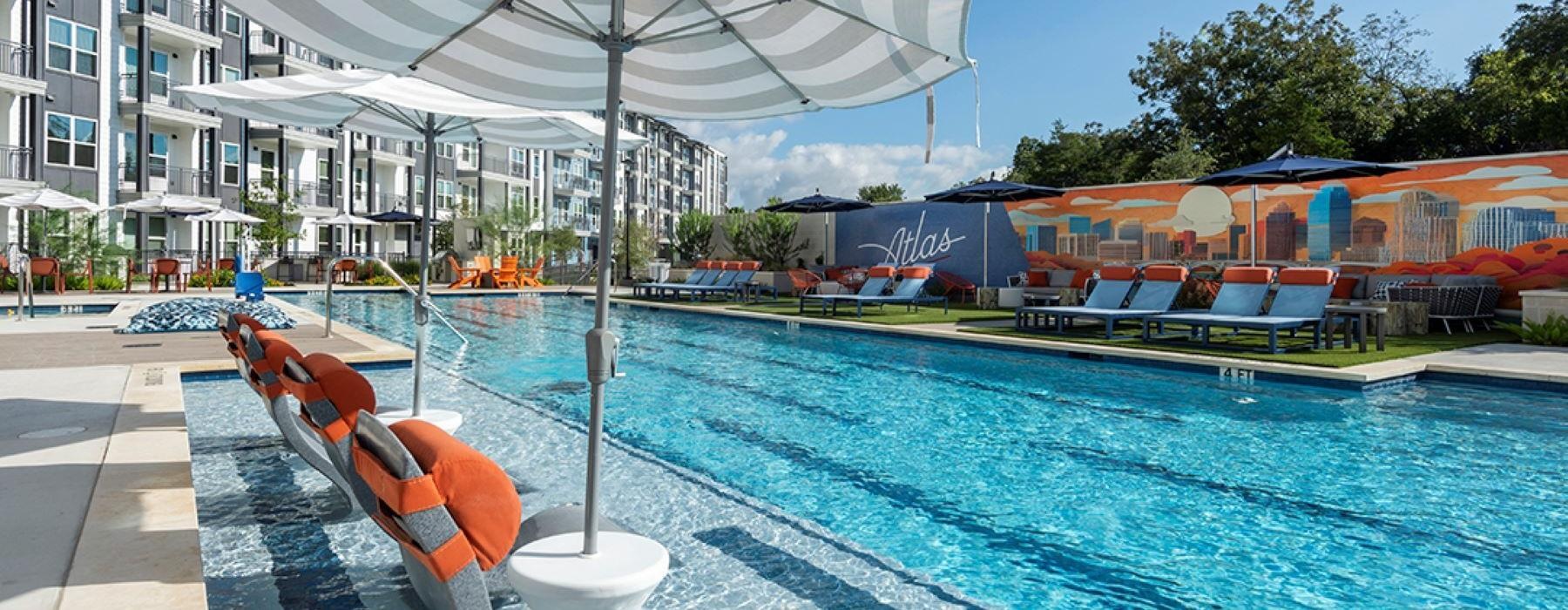 a pool with chairs and umbrella